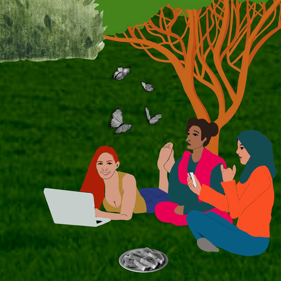 A group of women sitting together on the grass, deep in dialogue. One is taking notes on her laptop and another is using her phone. Butterflies float overhead and there is a plate of watermelon in front of them.